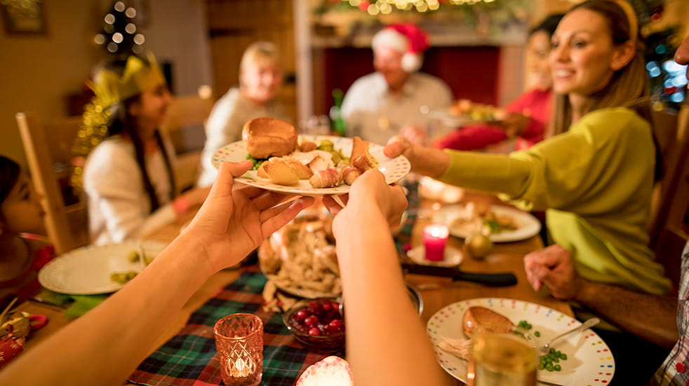 How to save money on Christmas: a family enjoying Christmas dinner
